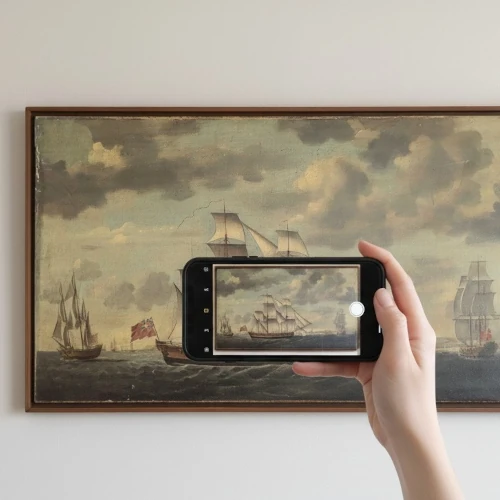 Hand holding phone taking photo of artwork
